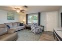Comfortable living room with neutral walls, hardwood floors, and ample natural light from a large window at 7901 Marlboro Dr, Port Richey, FL 34668