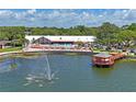 Community clubhouse featuring a pool, lounge area, and waterfront gazebo on a tranquil pond at 8405 Divot Way, Port Richey, FL 34668