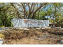 Timber Oaks community entrance sign surrounded by mature trees and lush landscaping at 8405 Divot Way, Port Richey, FL 34668