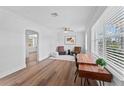Bright living room featuring hardwood floors, ceiling fan, and neutral paint, with large windows allowing ample natural light at 9000 Bay Ne St, St Petersburg, FL 33702