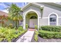 Home front entrance with arched entry way, double doors and manicured landscaping at 9813 Woodbay Dr, Tampa, FL 33626