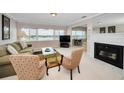 Bright living room featuring large windows with water views and a cozy fireplace at 100 Bluff View Dr # 511C, Belleair Bluffs, FL 33770