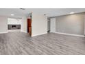 Open-concept living room with hardwood floors, neutral walls, and view of a fireplace and kitchen at 11490 48Th N Ave, St Petersburg, FL 33708