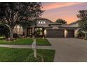 Dusk view of a well-maintained single-story home with three-car garage and manicured lawn at 1342 Salmonberry St, Wesley Chapel, FL 33543