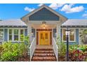 Inviting entrance featuring brick steps, white railings, and a vibrant yellow front door at 1400 Cherry Ne St, St Petersburg, FL 33704