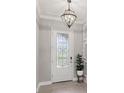 Elegant front entryway featuring a decorative glass door, tiled floor, and stylish light fixture at 1902 Marshberry Ct, New Port Richey, FL 34655