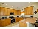 Efficient kitchen with wood cabinets, stainless steel appliances, and breakfast bar at 2038 Oswego Dr, Holiday, FL 34691