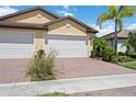 Charming home featuring a brick driveway, two-car garage, and well-maintained landscaping at 21008 Fetterbush Pl, Venice, FL 34293