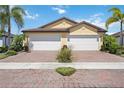 Charming home featuring a brick driveway, two-car garage, and well-maintained landscaping at 21008 Fetterbush Pl, Venice, FL 34293