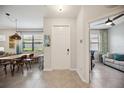 Bright foyer with gray tile flooring, open to the dining and living room, with a view of office at 21008 Fetterbush Pl, Venice, FL 34293
