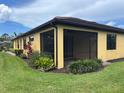 Screened patio, perfect for enjoying the outdoors with beautiful landscaping and well-maintained green grass at 21008 Fetterbush Pl, Venice, FL 34293