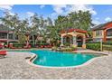 Community pool featuring a waterfall and covered gazebo with lounge seating at 2171 Portofino Pl # 27-2725, Palm Harbor, FL 34683