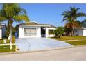 Lovely single-story home featuring mature trees, well-maintained landscaping, and a spacious driveway at 2211 Harrison Dr, Holiday, FL 34691