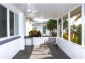 Relaxing screened porch with comfortable seating, ceiling fan, and serene outdoor views at 2211 Harrison Dr, Holiday, FL 34691