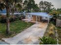 Inviting single-story home with a carport, surrounded by lush landscaping and a spacious front yard at 224 Georgia Ave, Crystal Beach, FL 34681