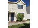 Two-story home with cream siding, dark blue door, and a garden with red flowers in front at 2302 Maki Rd # 2, Plant City, FL 33563