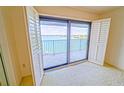 This bedroom has ample natural light and a sliding glass door leading to a balcony with a water view at 240 Sand Key Estates Dr # 243, Clearwater Beach, FL 33767