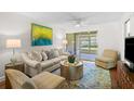 Bright living room with a comfortable sofa, stylish rug, and a sliding glass door to a screened patio at 2460 Northside Dr # 802, Clearwater, FL 33761