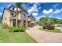 Elegant two-story home showcases a stone facade, verdant landscaping, and a spacious brick paver driveway at 2566 Lake Manor Dr, Land O Lakes, FL 34639