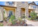 Inviting front porch featuring stone accents, a cozy bench, and a charming brick pathway at 2566 Lake Manor Dr, Land O Lakes, FL 34639