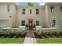Close up of arched front entry with balcony, tan stucco, red tile roof, and brick walkway at 2900 W Estrella St, Tampa, FL 33629
