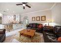 Open concept living room with white cabinets, tile floors, leather furniture, and ceiling fan at 2900 W Estrella St, Tampa, FL 33629