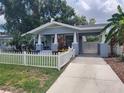 Charming single-story home featuring a cute picket fence and a covered carport on a sunny day at 318 W Crest Ave, Tampa, FL 33603