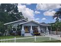 Charming single-story home with a cute picket fence, well-manicured lawn, and inviting front porch at 318 W Crest Ave, Tampa, FL 33603