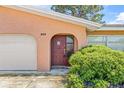 Close up of a well-maintained home featuring a red front door and lush landscaping at 358 Suwanee Ave, Sarasota, FL 34243