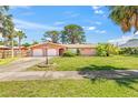 Inviting exterior showcasing a well-manicured lawn, mature palms and a two-car garage at 358 Suwanee Ave, Sarasota, FL 34243