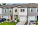 Charming townhome features a colorful door, manicured landscaping, and attached garage at 4338 Banjo Lake Rd, Land O Lakes, FL 34639
