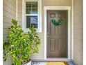 Inviting front door with a wreath, bright sidelight window, and a charming potted plant at 4338 Banjo Lake Rd, Land O Lakes, FL 34639