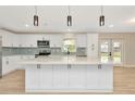 Modern kitchen featuring white cabinets, a large island with quartz countertops, and stainless appliances at 5749 Southernview Dr, Zephyrhills, FL 33541