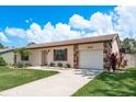 Single-story home with stone accents and attached one-car garage featuring a well-manicured lawn at 630 Kirkland Cir, Dunedin, FL 34698
