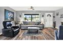 Inviting living room with wood floors, a ceiling fan, and bright natural light at 7305 Jasmine Blvd, Port Richey, FL 34668