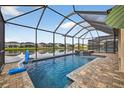 Enjoy the serene lake view from this beautiful screened-in pool with integrated spa at 7570 Sweeter Tide Trl, Wesley Chapel, FL 33545