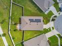 Aerial view showcasing a home's roof with solar panels and a spacious, green backyard at 8174 Wheat Stone Dr, Zephyrhills, FL 33540
