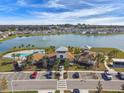 Aerial shot of a community pool, beach, parking lot, and recreational facilities by a lake at 8174 Wheat Stone Dr, Zephyrhills, FL 33540