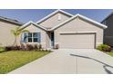Inviting one-story home with a well-manicured lawn, stylish shutters, and a convenient two-car garage at 8210 Juning Cv, Wesley Chapel, FL 33545