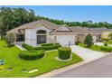 Beautiful single-story home featuring well-maintained landscaping and a spacious driveway leading to a two-car garage at 9751 Conservation Dr, New Port Richey, FL 34655