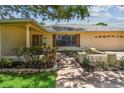 Close up of the front facade including a well maintained flower bed, stone trim, and stylish shutters at 1443 54Th Ne Ave, St Petersburg, FL 33703