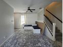 Bright living room with ceiling fan, large windows, staircase, gray walls, and built in bench seating at 1015 Windton Oak Dr, Ruskin, FL 33570