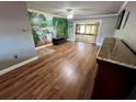 Spacious living room with natural light, wood floors, and sliding doors to screened lanai at 1025 82Nd N Ter # 1025D, St Petersburg, FL 33702