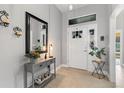 Bright foyer boasts tile floors, a decorative mirror, console table, and natural light streaming through the front door at 12004 Legacy Bright St, Riverview, FL 33578