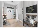 Welcoming foyer with decorative bench, tile flooring, stylish decor, and a well-lit entry at 12004 Legacy Bright St, Riverview, FL 33578