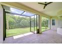 Enclosed patio with tile flooring overlooking a serene backyard, perfect for outdoor relaxation and entertaining at 1208 Carriage Park Dr, Valrico, FL 33594