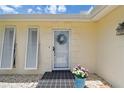 Front entrance of the home with a decorative wreath and vibrant flowers at 1270 Inverness, Dunedin, FL 34698