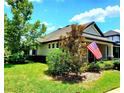 Charming single-story home with American flag, well-kept landscaping, and beautiful green lawn at 12862 Rangeland Blvd, Odessa, FL 33556