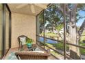 Screened balcony with peaceful views of the lake, ceiling fan, and comfortable furniture at 14130 Rosemary Ln # 3202, Largo, FL 33774
