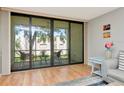 Bright living room featuring sliding glass doors to the screened balcony and beautiful hardwood floors at 14130 Rosemary Ln # 3202, Largo, FL 33774